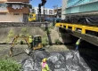 Grúa bajando una excavadora al cauce para una obra de saneamiento de ríos en Panamá